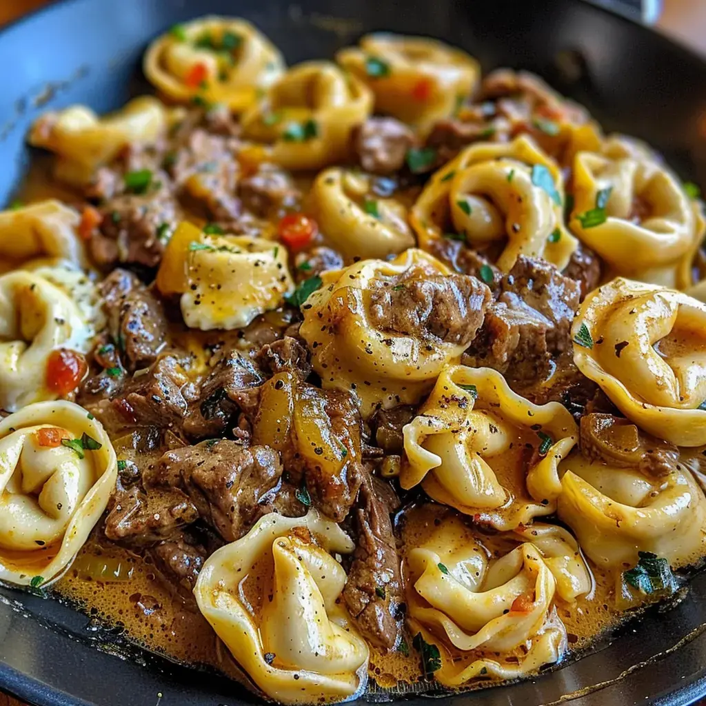 Un plat de pâtes farcies avec des morceaux de viande et des légumes dans une sauce savoureuse.