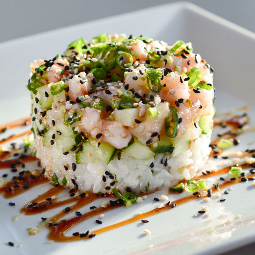 Une salade de crevettes nordiques façon tartare est servie sur un plateau en verre.