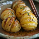 Des pommes de terre rôties en tranches, assaisonnées de thym et de poivre, dans une assiette.