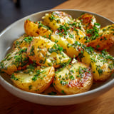 Une assiette de pommes de terre à l'ail et au beurre au four, prête à être servie.