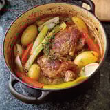 Une cocotte en fonte contenant des légumes et du porc braisé.
