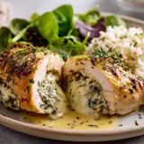 Un poulet farci au fromage brie sur un plateau.