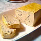 Une terrine de foie gras de Joël Robuchon est sur une plaque de verre.
