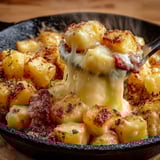 Une truffade au cantal fondant est servie dans un bol en fonte.