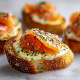 Pain à l’ail gratiné au saumon fumé spécial Noël, avec des herbes fraichées et du fromage.