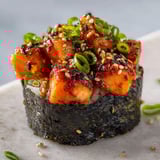 Un plat de sushi avec des légumes verts et des grains de riz.