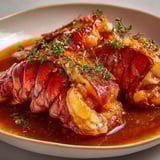 Queues de langouste mijotées dans une sauce fine au vin blanc et cognac.