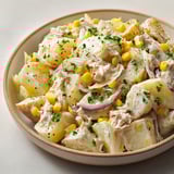 Une salade d'endives, pommes de terre et thon est servie dans un bol.