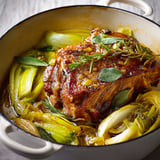 Un plat de porc en cocotte aux poireaux, avec des légumes verts et des herbes.