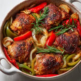 Une casserole de poulet et légumes rôtis au four, avec des légumes verts et des épices.