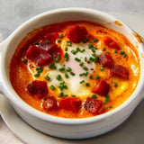 Œufs fondants à la crème de chorizo mixée, entrée chaude riche et parfumée avec sauce douce et relevée.