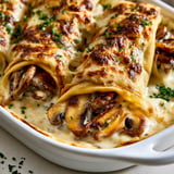 Une assiette de crêpes salées champignons et béchamel, prêts à être servies.