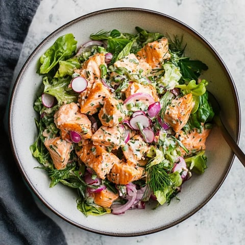 Salade de saumon grillé accompagnée de laitue, radis, et d'une sauce crémeuse.