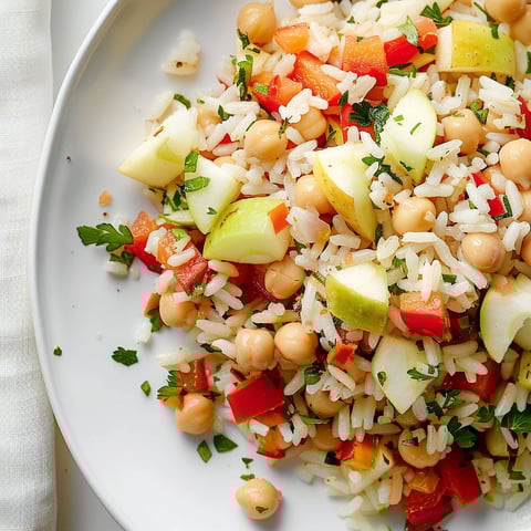 Une salade de riz aux pommes et au poivron est servie sur un plateau.