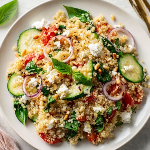 Une salade de quinoa, ricotta, épinards et oignons rouges est servie sur un plateau.