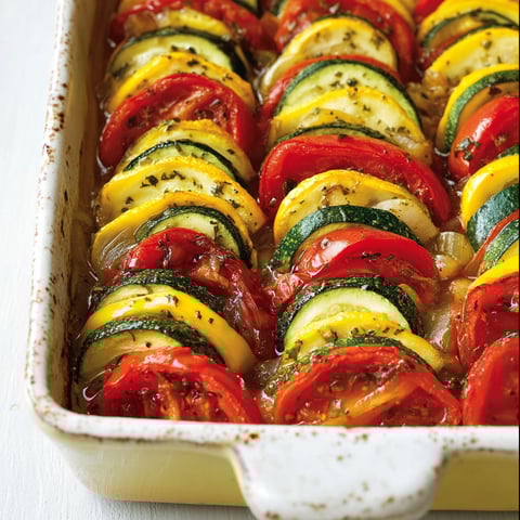 Une tian de courgettes est servie dans un plat en verre.