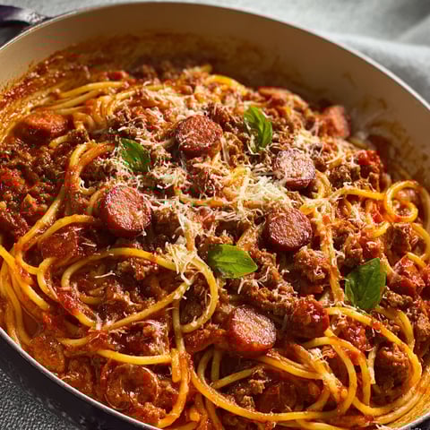 Une casserole de spaghetti au bœuf haché et saucisse fumée.