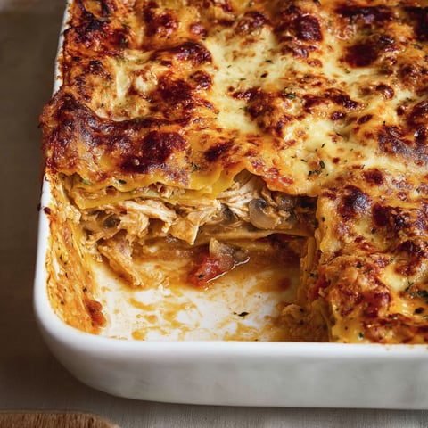 Une pièce de lasagne cacciatore est servie dans un plat en verre.