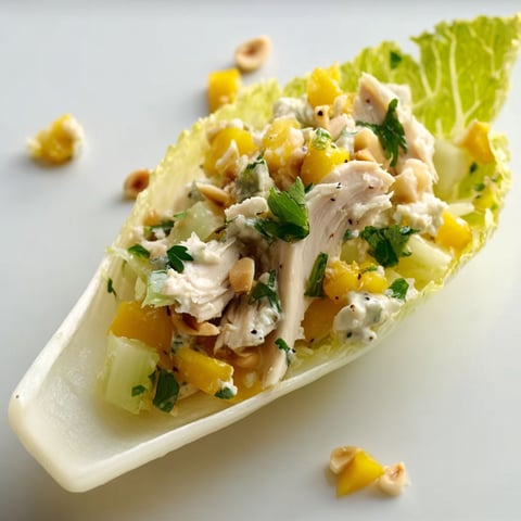 Feuilles d’endive farcies au poulet, mangue et touche citronnée.