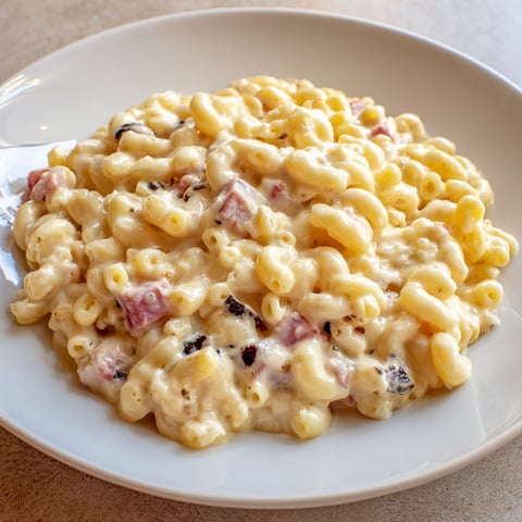 Une assiette de macaroni au fromage et aux coquillages, servie sur un plateau.
