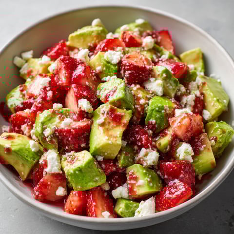 Une salade de fraises, avocat et chèvre frais, servie dans un bol.